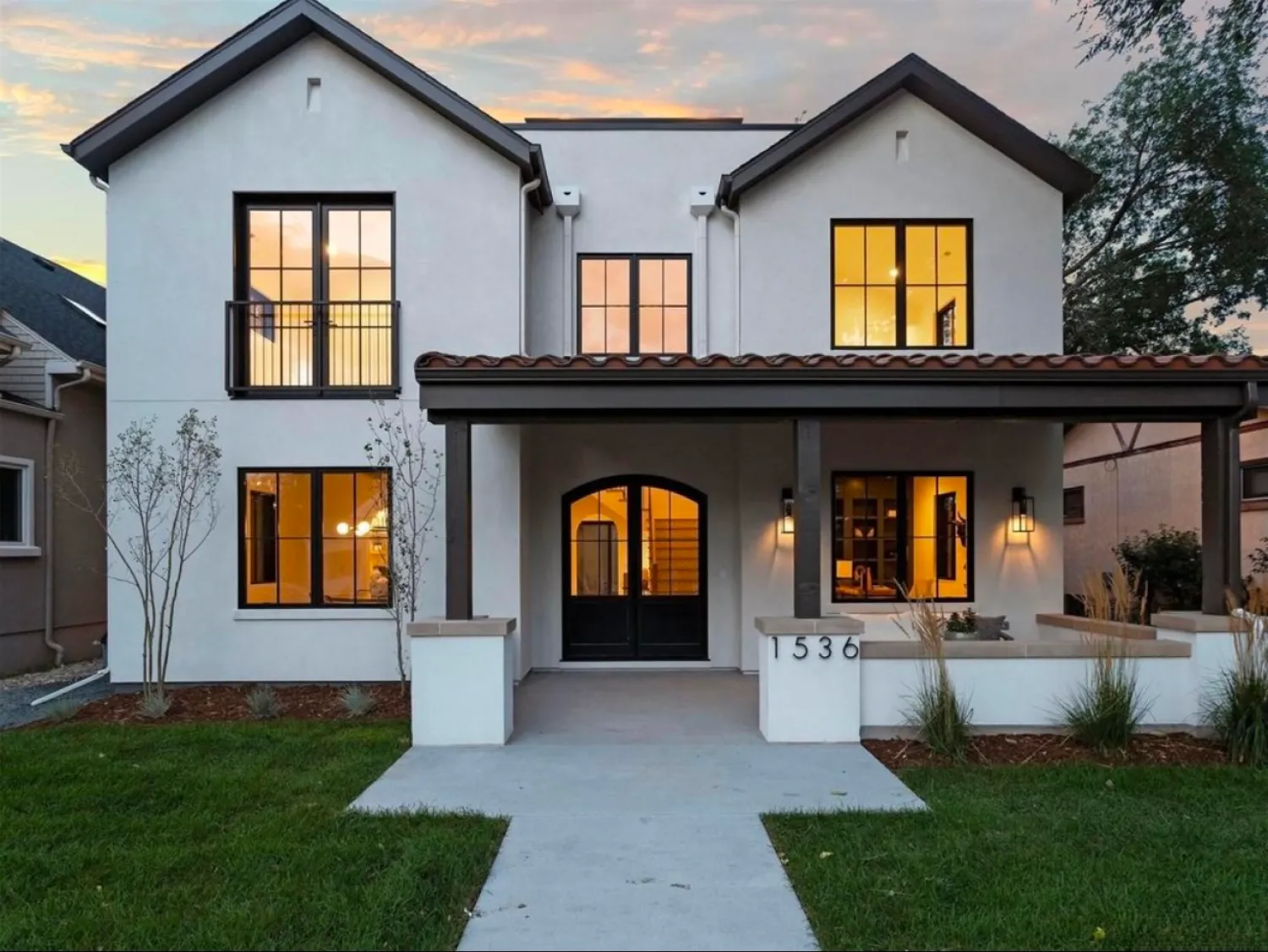 residential-exterior-5 Modern two-story house with large windows and front porch, lit warmly at dusk, address 1536.