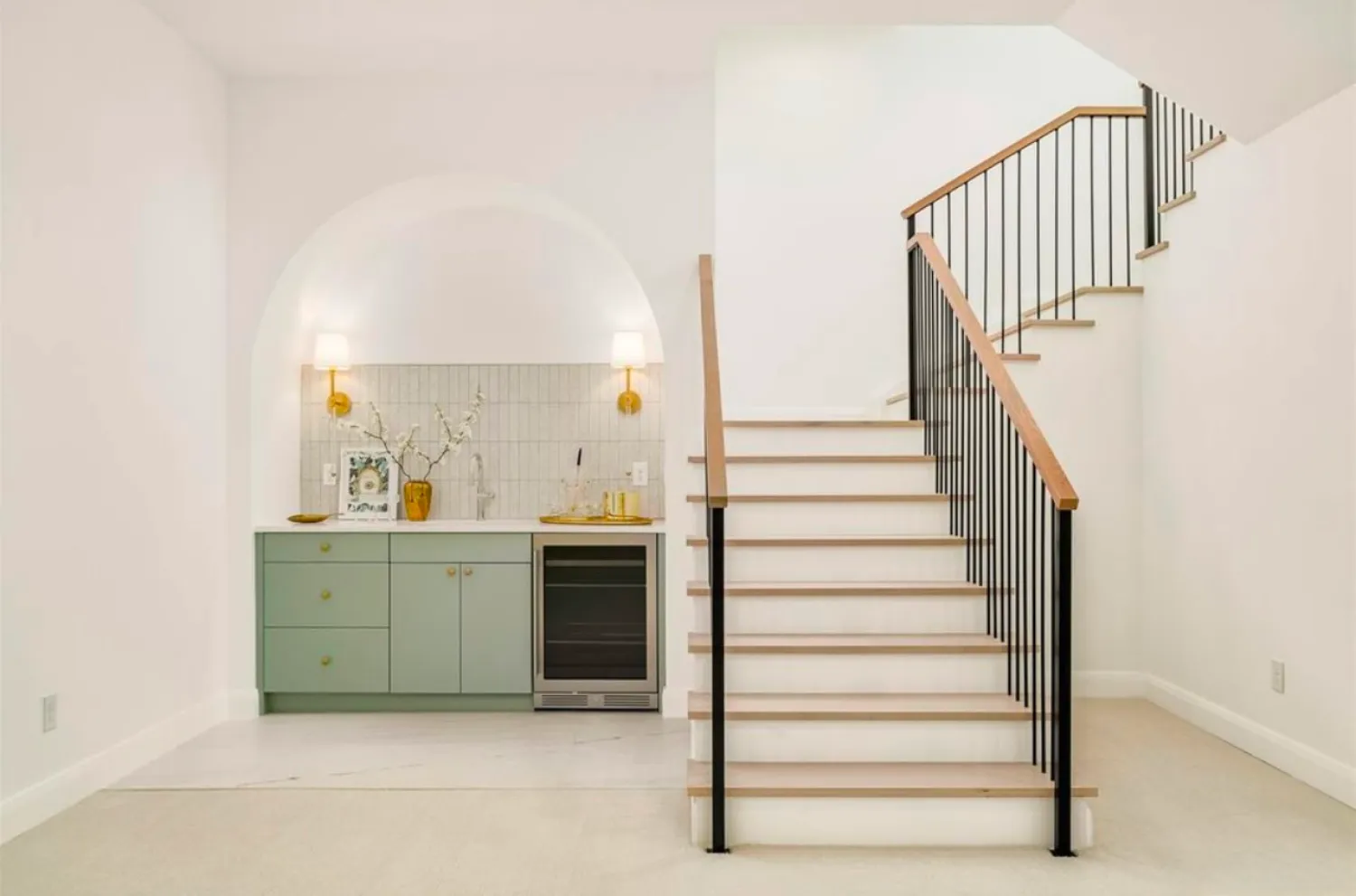residential-interior-38 A modern staircase beside a small green kitchenette with gold accents and wall sconces.